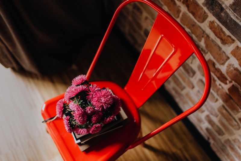 kaboompics_Industrial red metal chair with a bouquet of pink flowers and books on it.jpg 方案配图,色彩意境,红色,