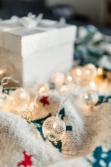 白色 kaboompics_White decorative gift box and Christmas lights on a blanket.jpg