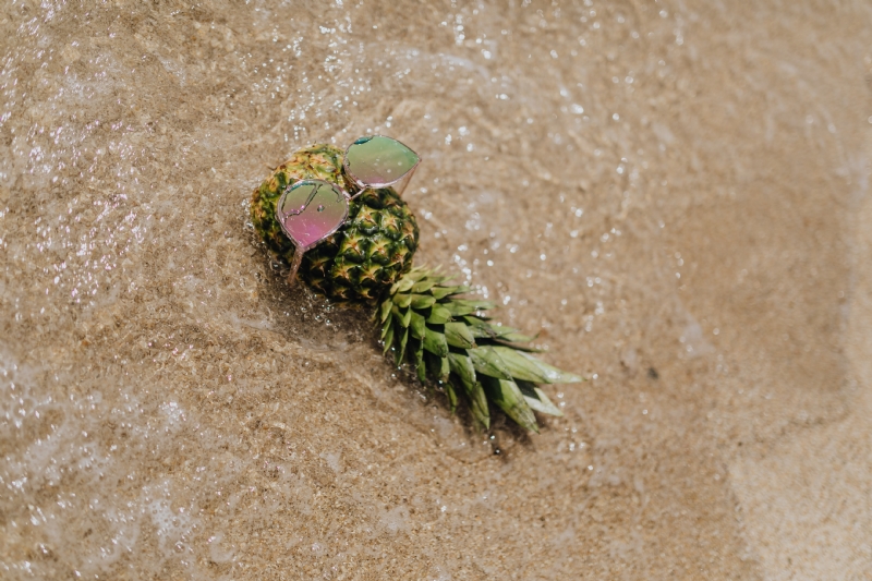 kaboompics_Pineapple with sunglasses on the beach.jpg 方案配图,色彩意境,褐色,