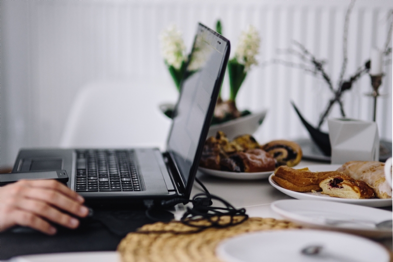 kaboompics_Black laptop on a table with cakes.jpg 方案配图,色彩意境,黑色,