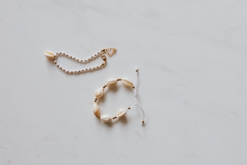 奢华 kaboompics_Gold jewellery in white marble - bracelets with shells.jpg