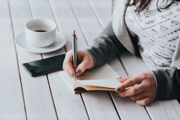 阅读 kaboompics_Coffee on table with a woman writing.jpg