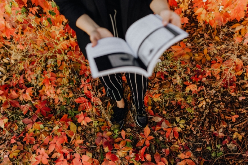 kaboompics_Girl with the Grafconf book on the background of coloured leaves-2.jpg 方案配图,客户爱好,阅读,