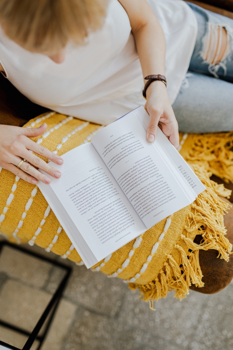 kaboompics_The woman is reading a book. She is sitting on a brown couch and a yellow blanket-2.jpg 方案配图,客户爱好,阅读,