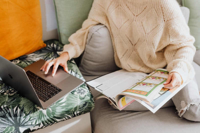 kaboompics_The woman is reading the newspaper and using a laptop.jpg 方案配图,客户爱好,阅读,