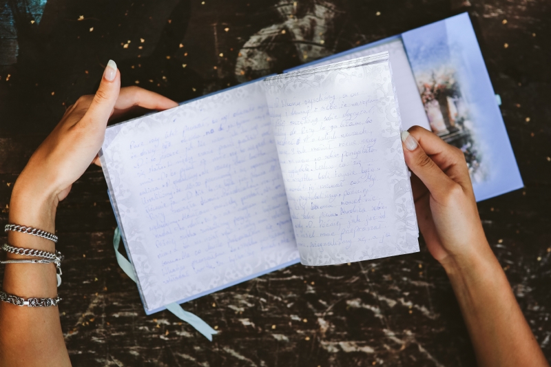 kaboompics_Woman reading a diary by a table.jpg 方案配图,客户爱好,阅读,